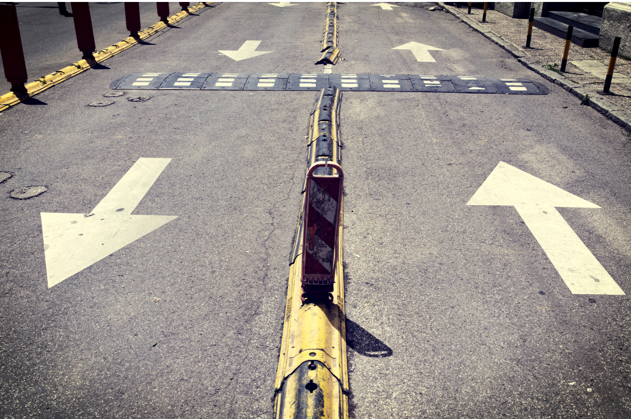 Das Bild symbolisiert Veränderungsprozesse durch eine Straße, auf der Pfeile in entgegengesetzte Richtungen zeigen.